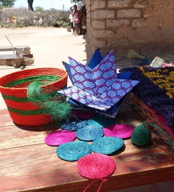 Baskets and other products made of sisal on a wooden table.